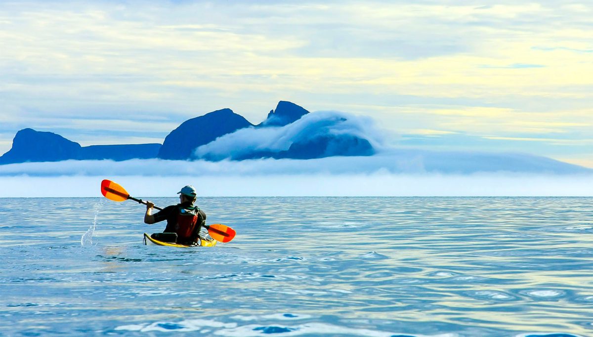 svart men kayak open sea summer